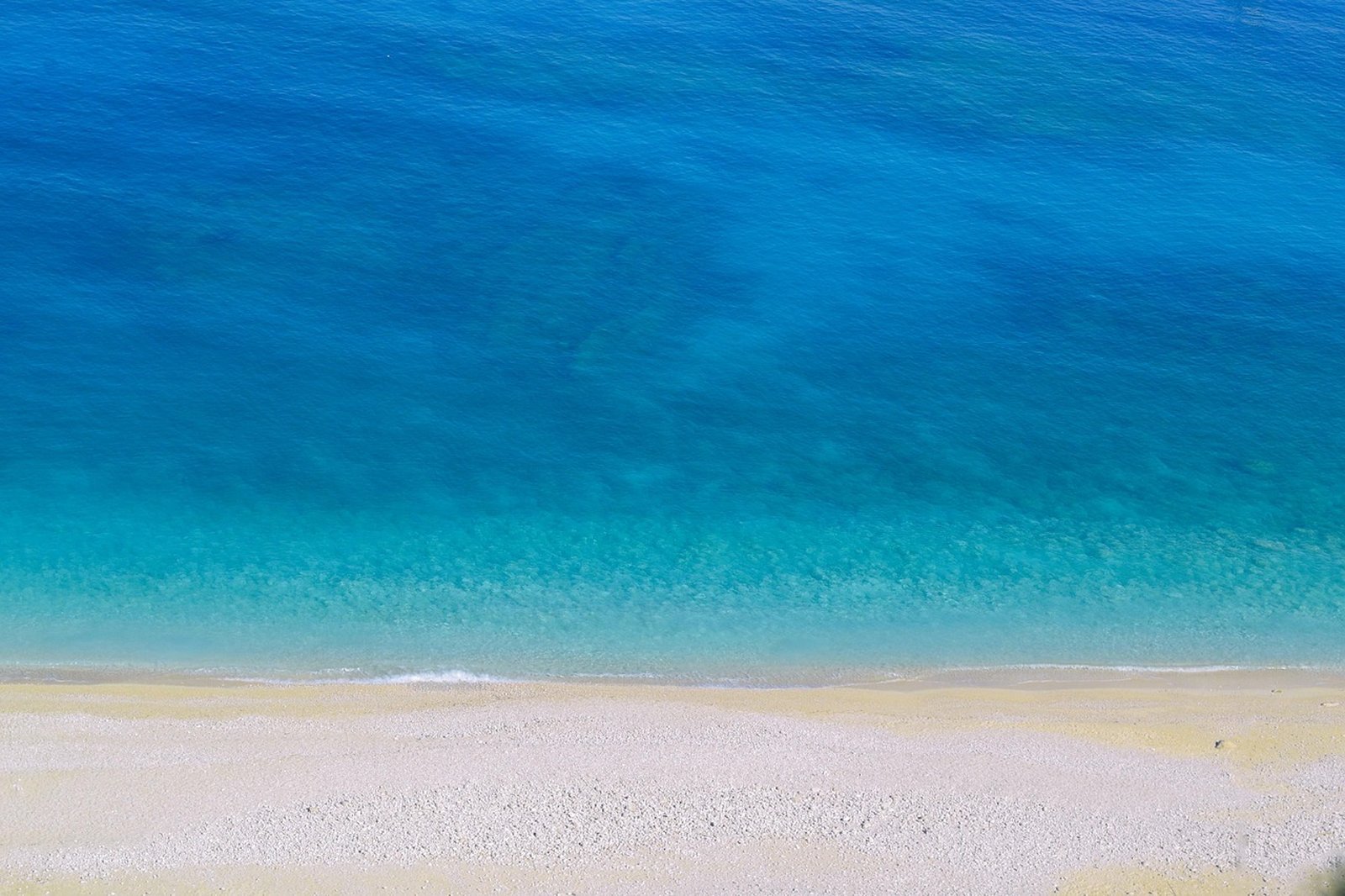 Turquoise water on a pale sand beach west of Chania, Crete
