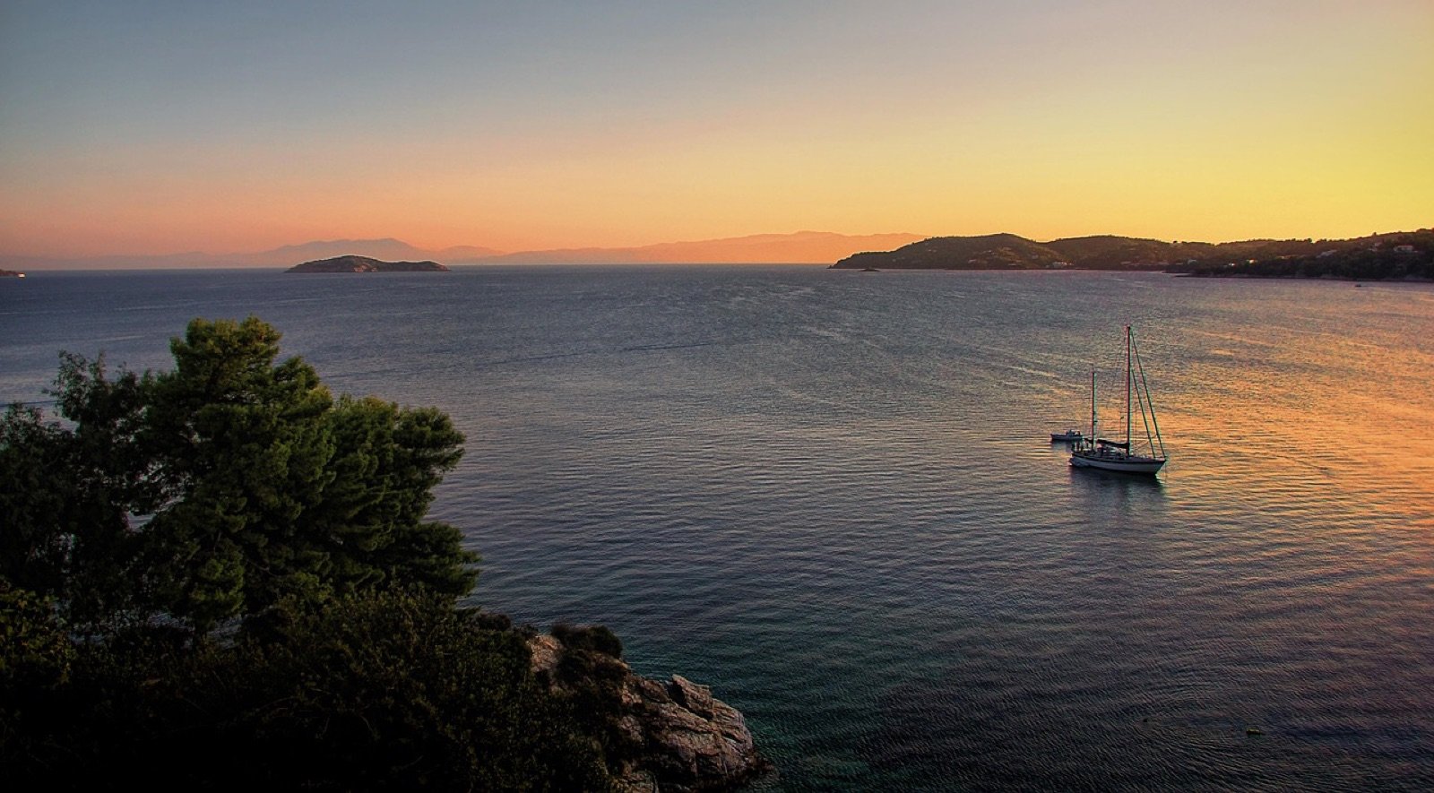 A sailboat under full sail at golden hour