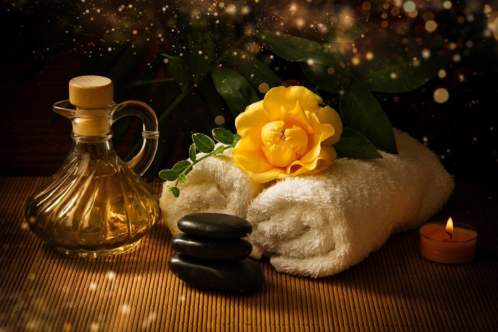 Spa oils, hot stones and a rolled towel by candlelight