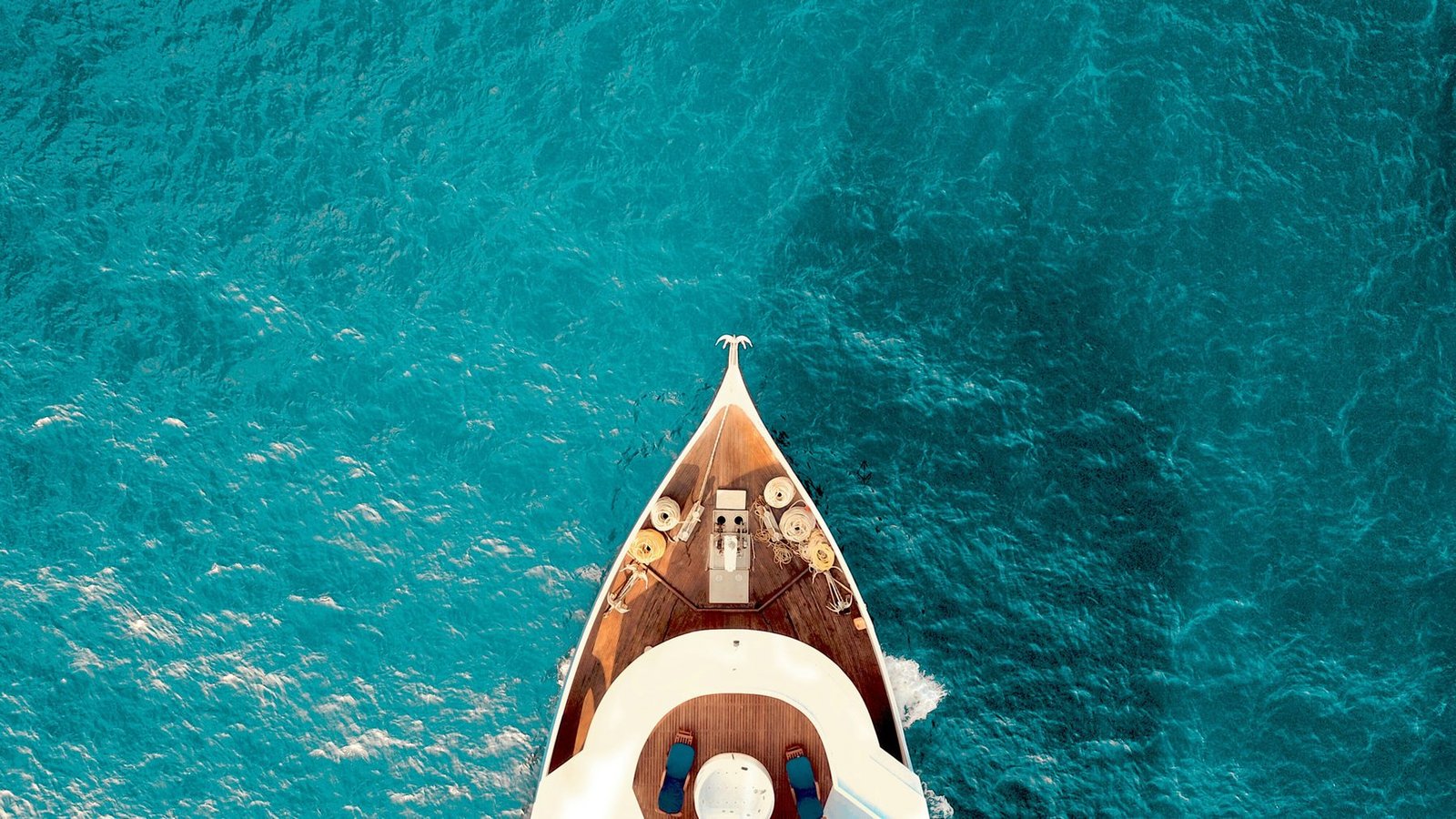 Aerial view of a yacht on turquoise water off Chania