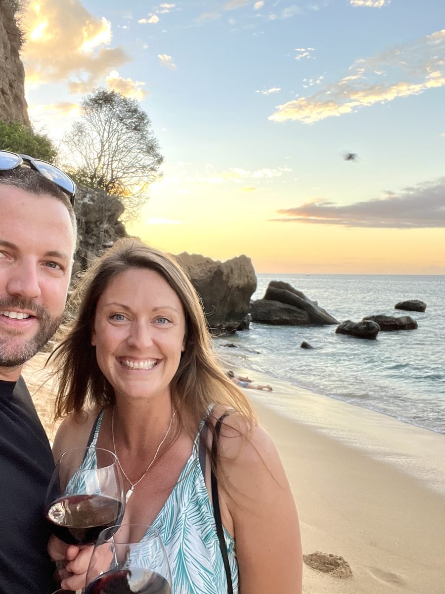 Dariece and Nick cheek to cheek at sunset with a glass of wine