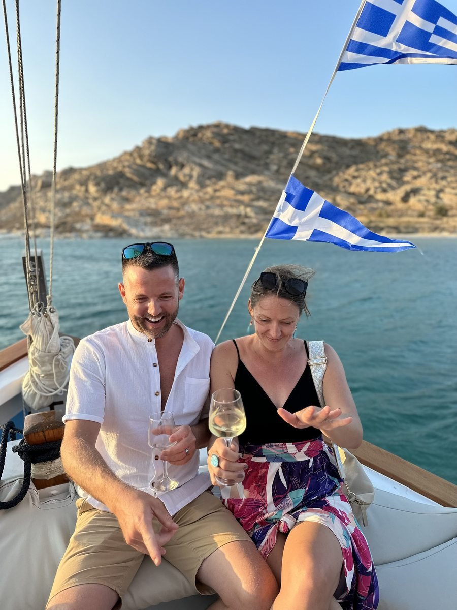 Dariece and Nick with a glass of wine on a sailboat in Greece