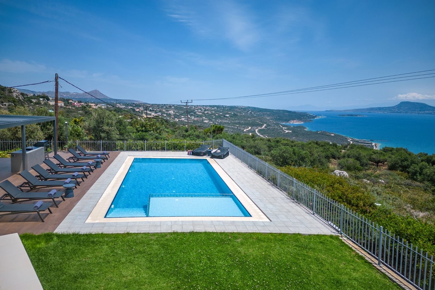 The villa pool and lawn looking over the bay of Chania