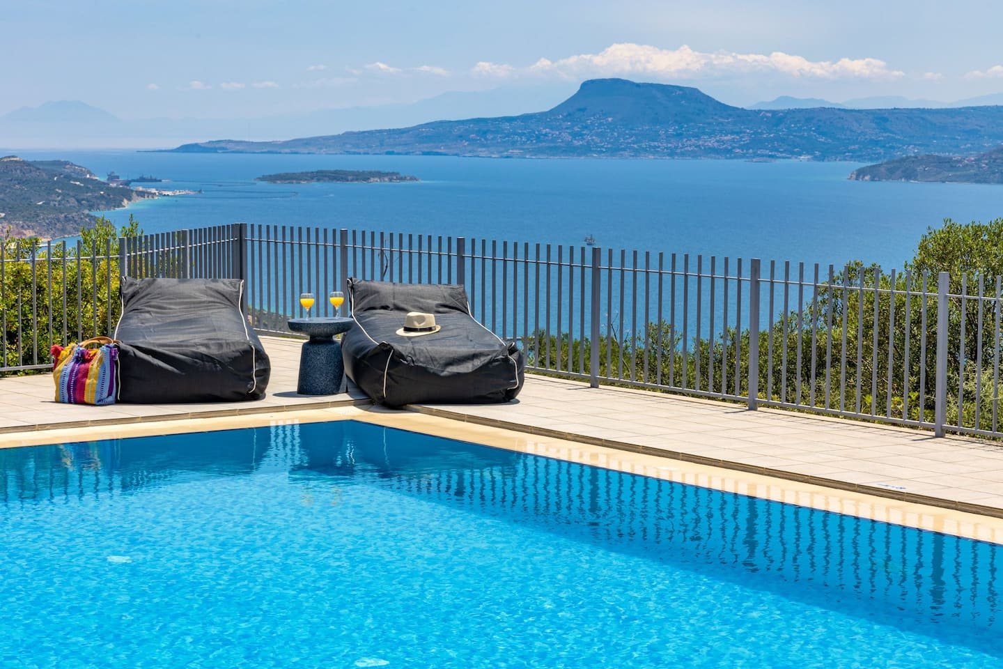 Loungers at the pool edge above the bay of Chania