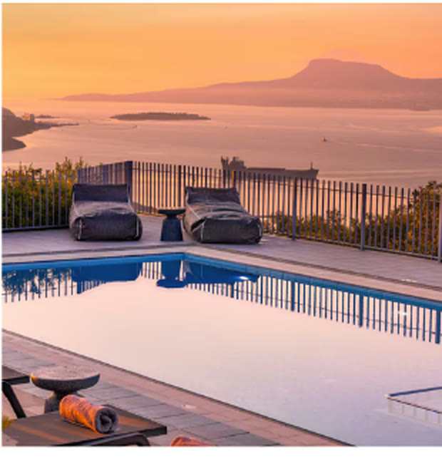 The villa pool at sunset over the bay of Chania